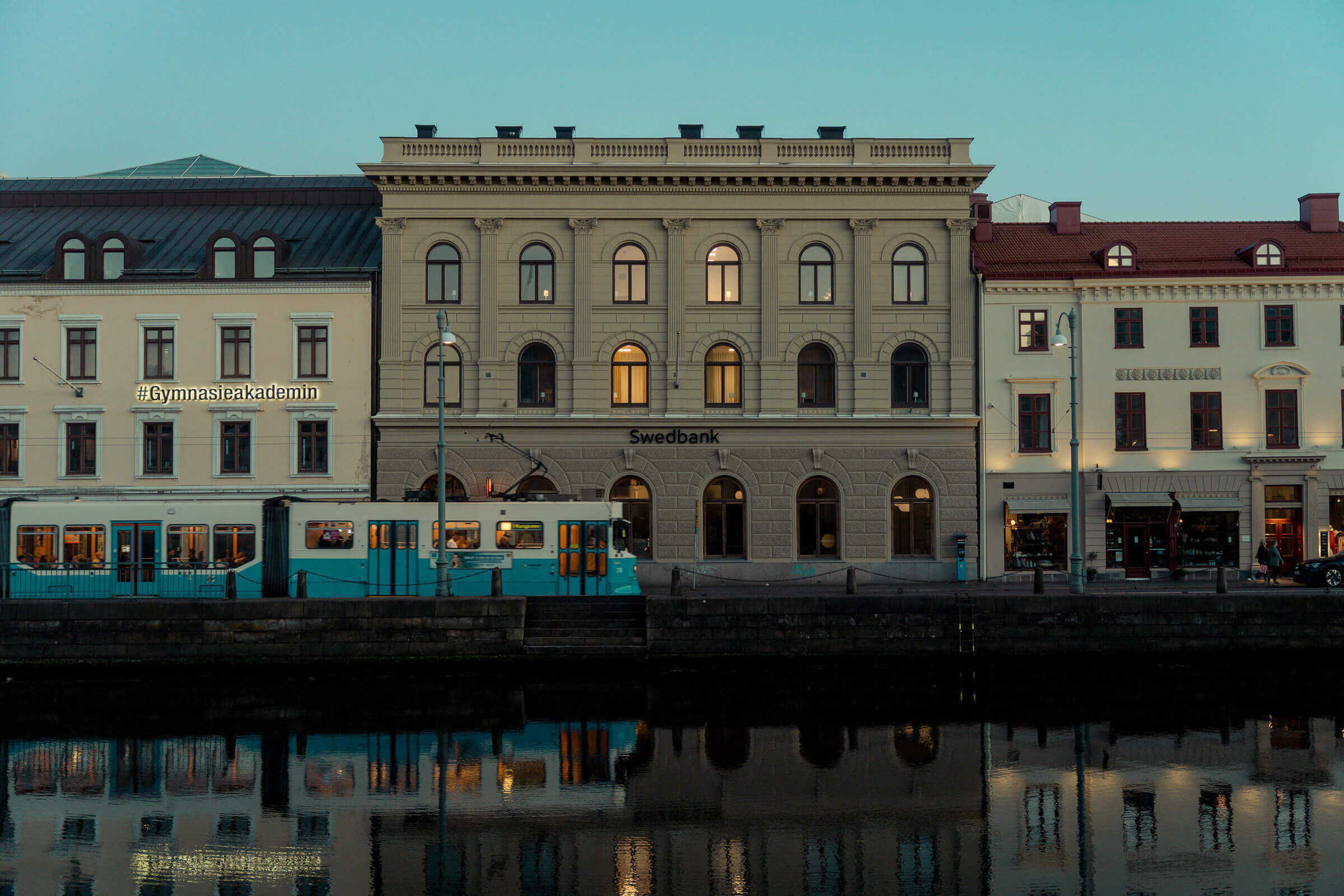 Fotograf tar bild på hus och spårvagn.